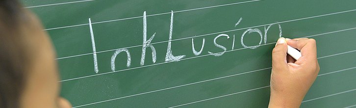Zu sehen ist eine Tafel, an die das Wort Inklusion geschrieben steht